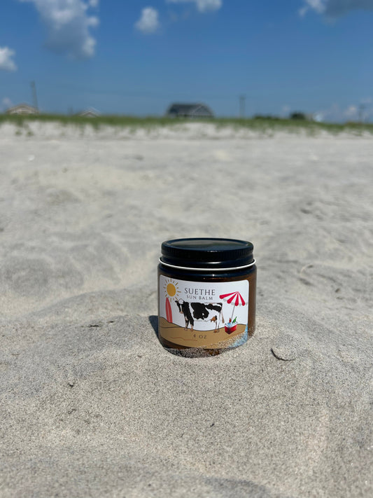 Tallow-based mineral sun balm with zinc oxide photographed on beach sand in natural light